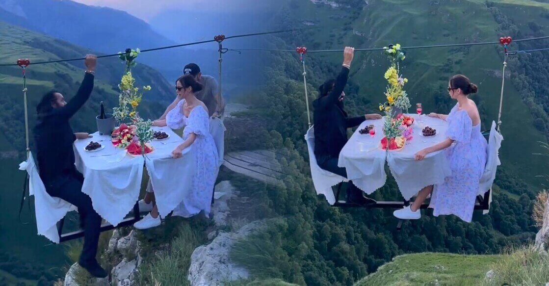 Bir Çiftin Tele Bağlı Masa Sistemiyle Bir Yamaçtan Vadiye Doğru İlerlediği Görülen Video cift-havada-yemek-masasi