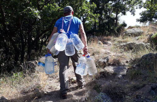 yangında damacana ile su taşıyan