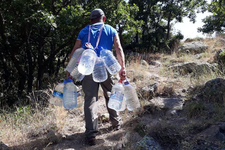yangında damacana ile su taşıyan